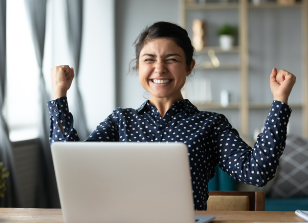 Woman celebrating in front of a computer - property investment services